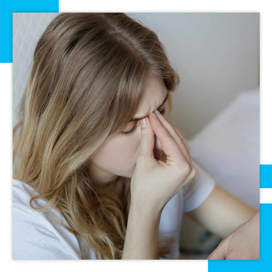 woman pinching bridge of nose