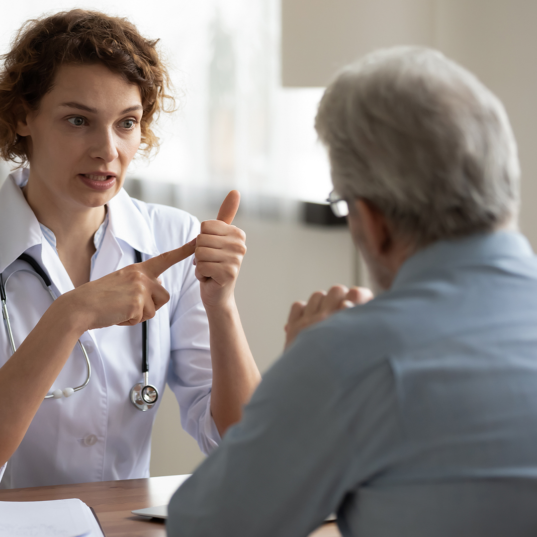 Doctor speaking with patient at a desk.