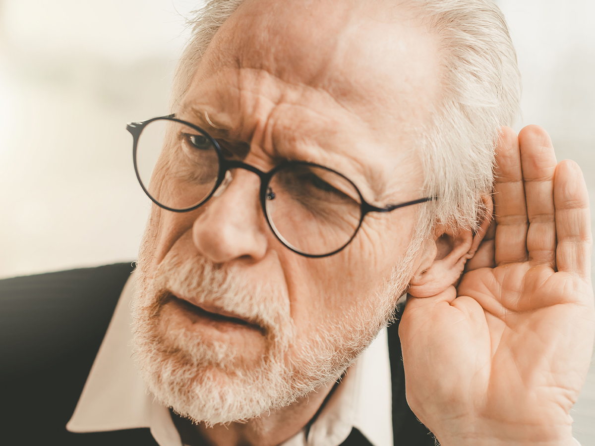 Old man cupping his hand to his ear.