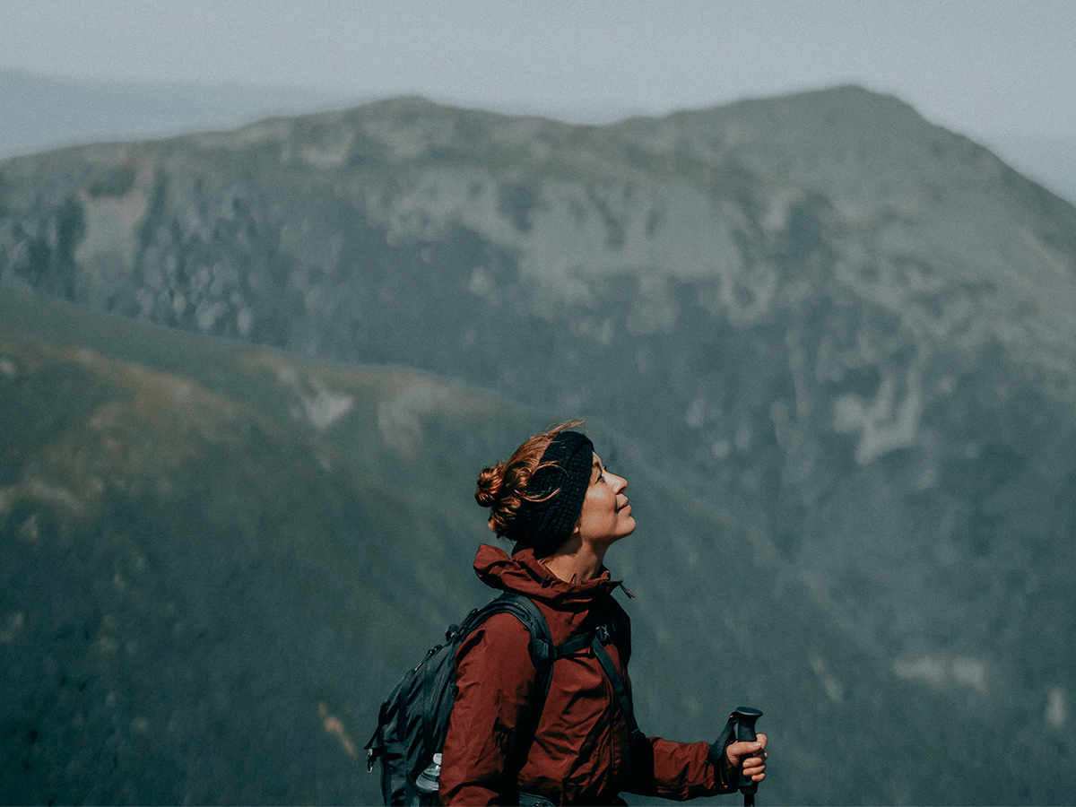 Woman breathing deep on a hike in the mountains