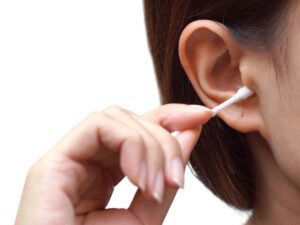 A woman cleaning out her ear wax