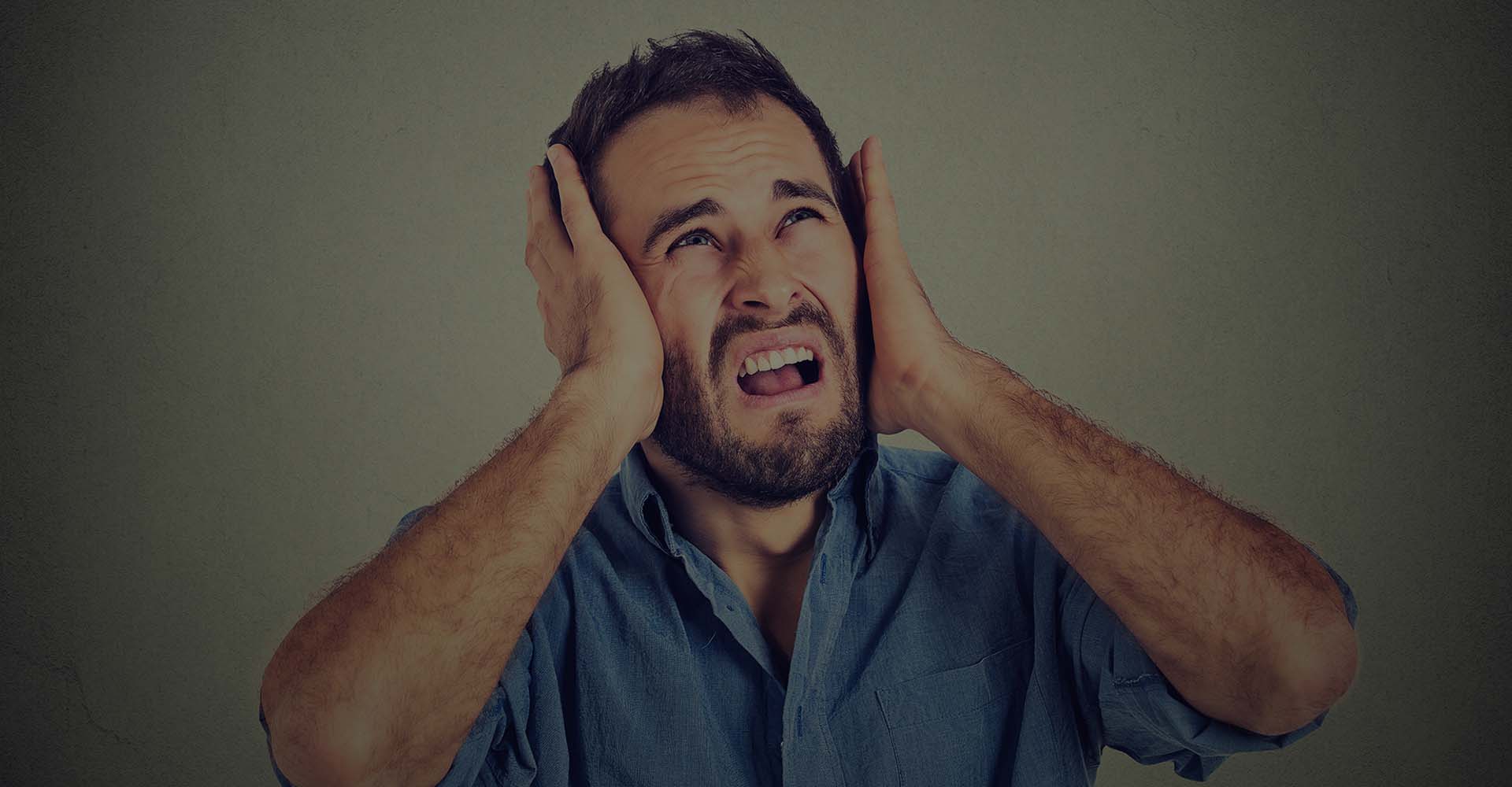 Man in pain covering his ears