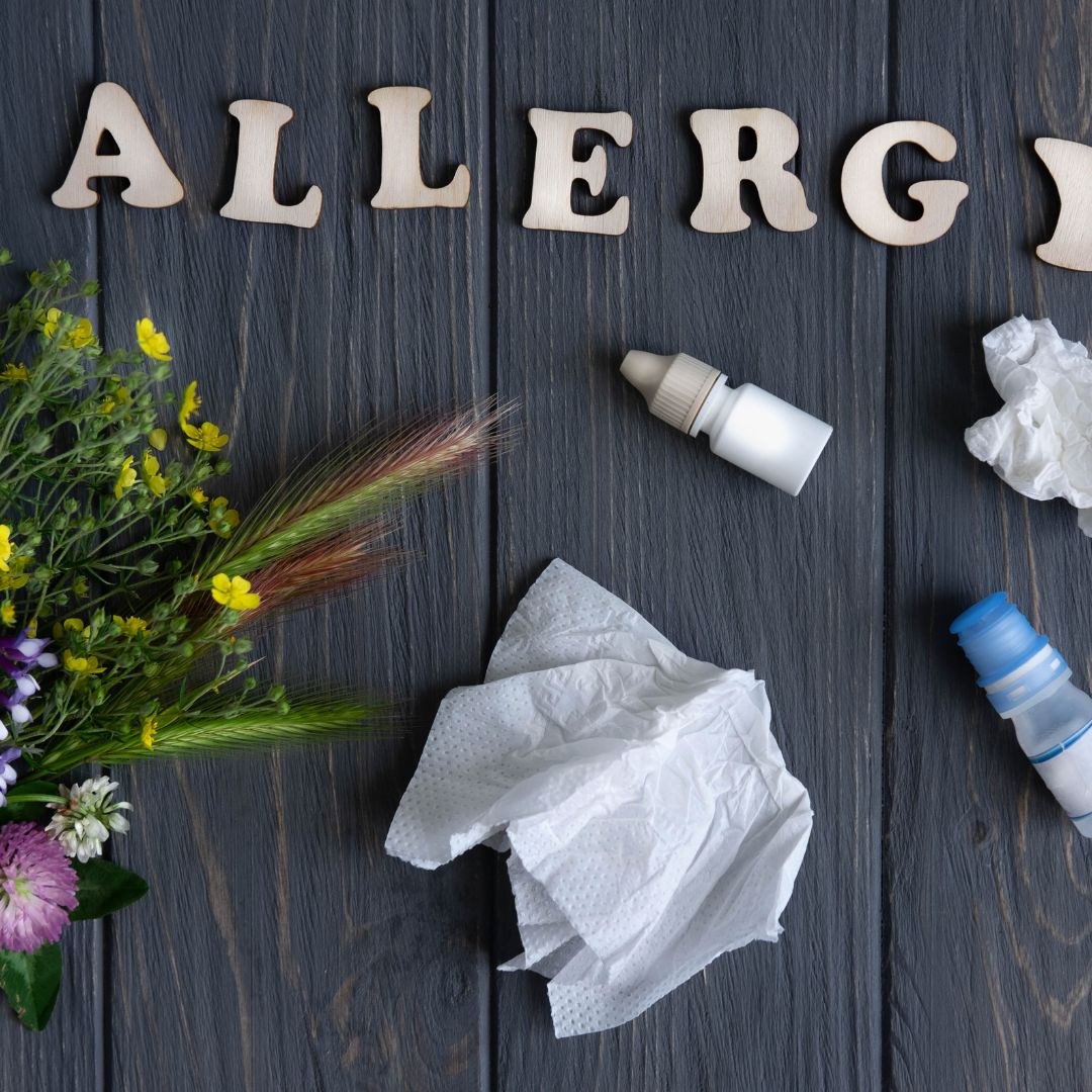 tissues, bottles, flowers and the word allergy spelled out