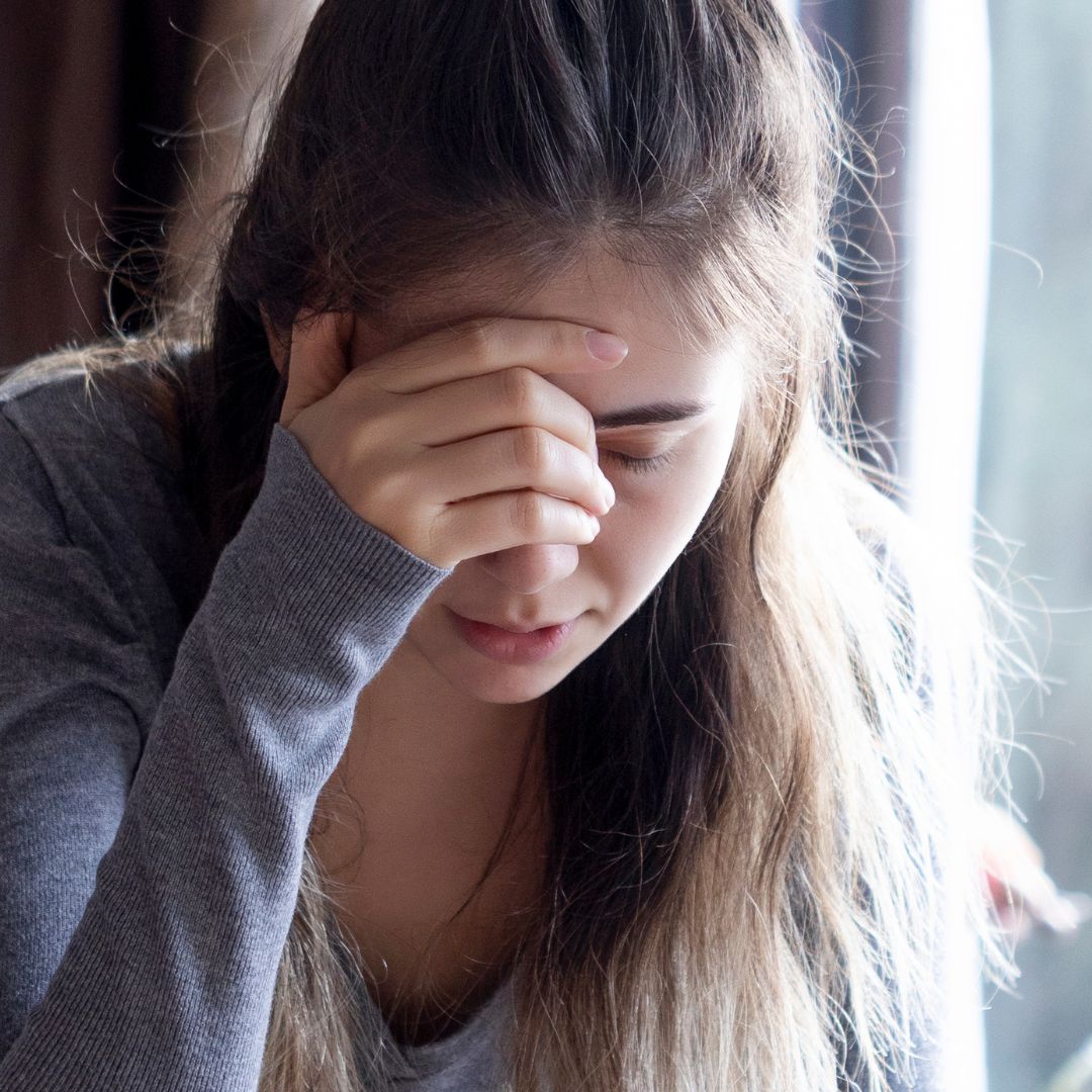woman holding forehead