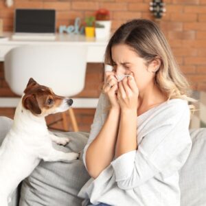 woman sneezing by a dog
