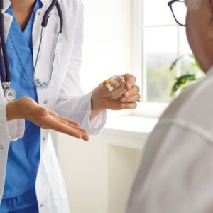 Doctor showing a patient a hearing aid