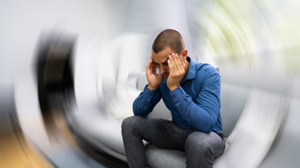 a man sitting down as the room spins