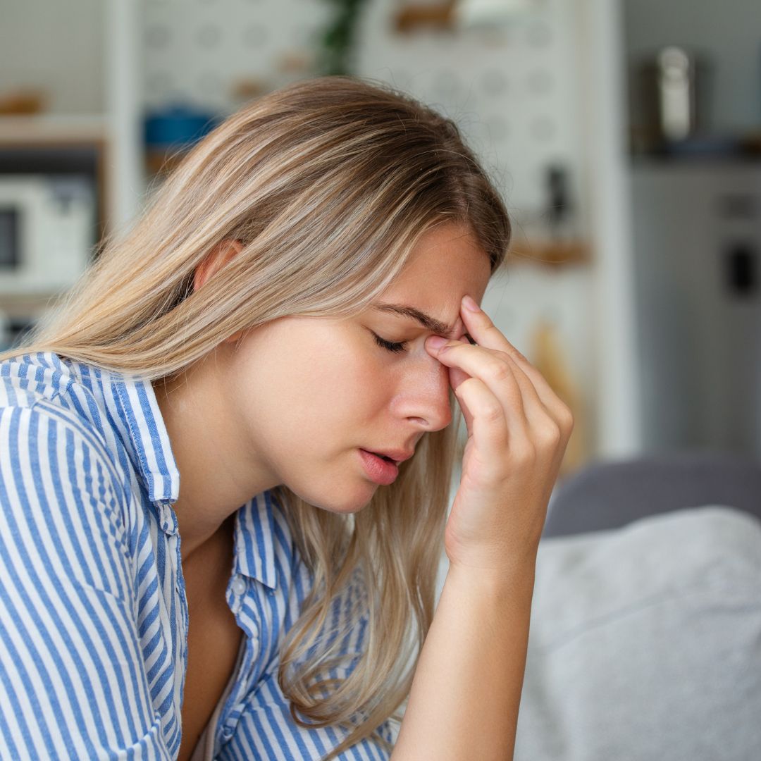 a woman holding her head in pain