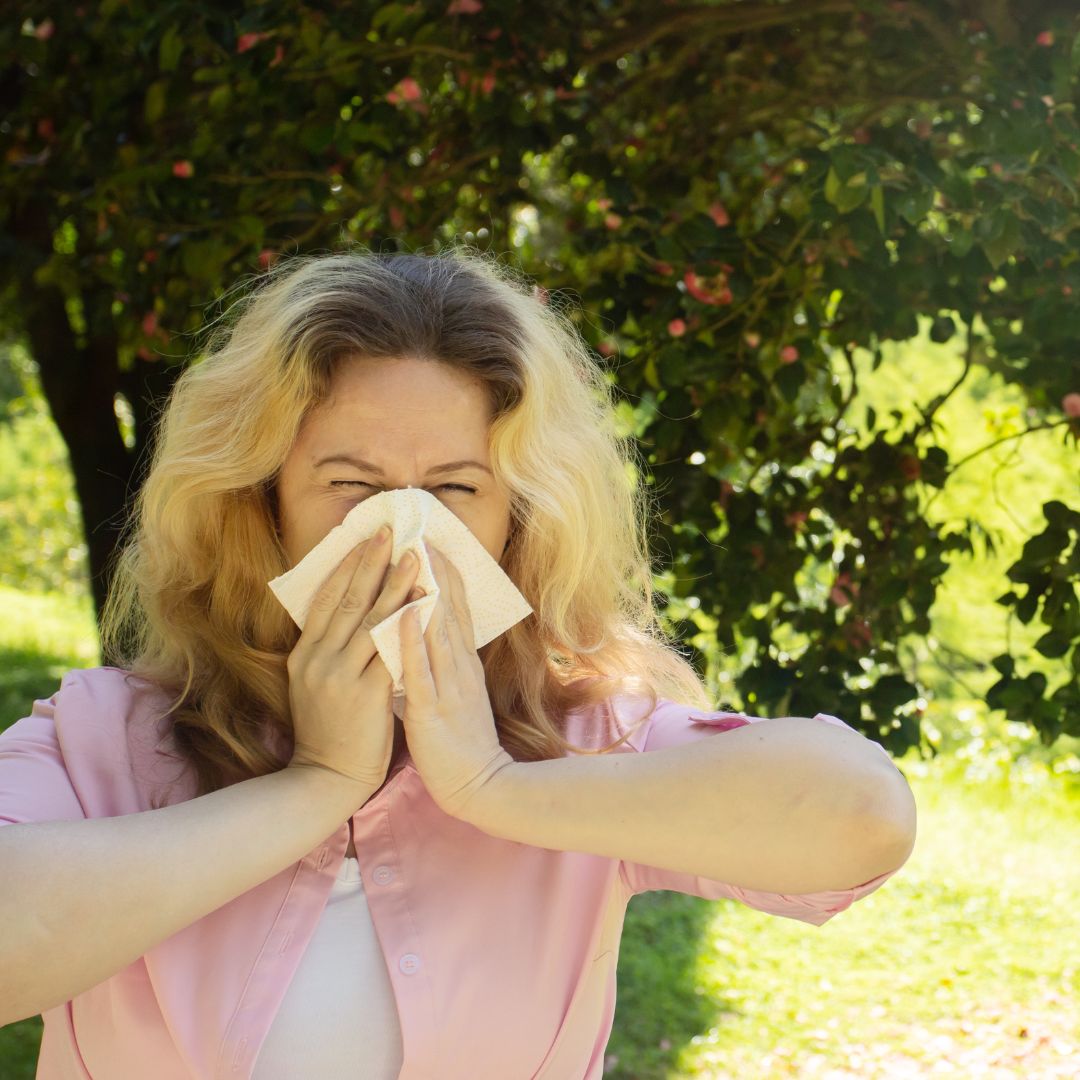 a woman blowing her nose outside
