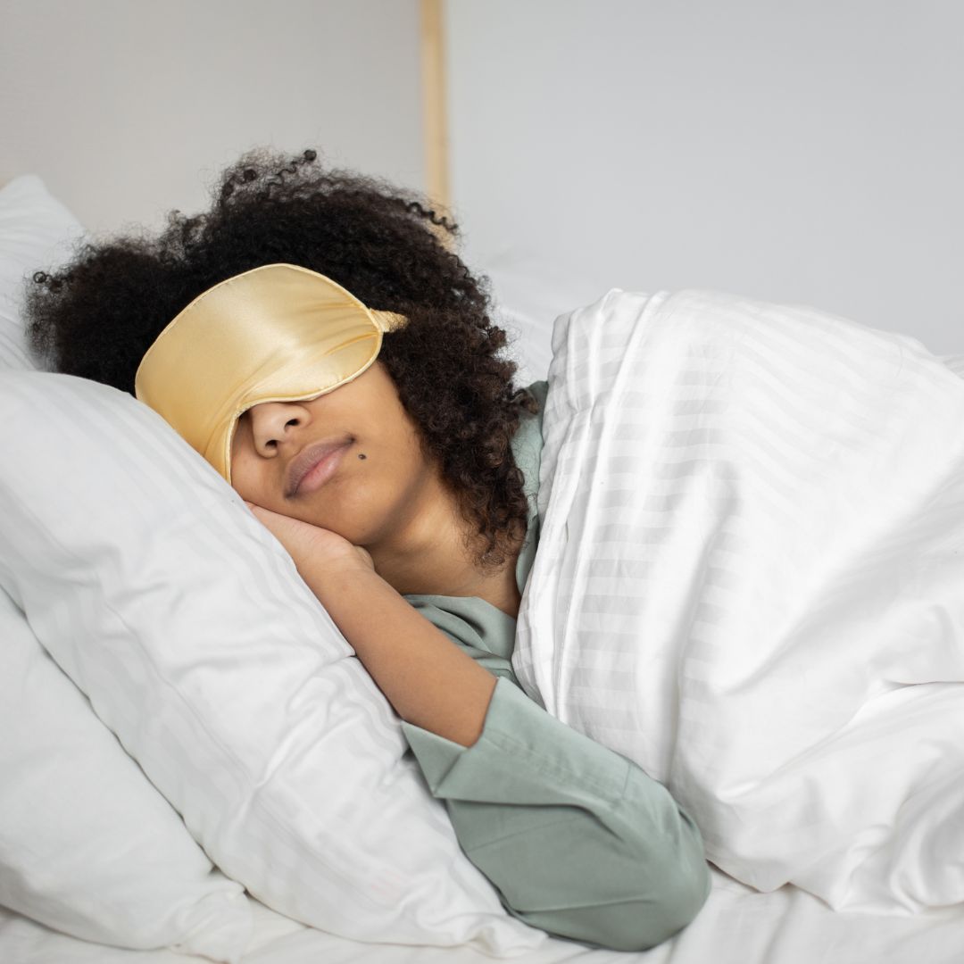 a woman sleeping with a sleep mask