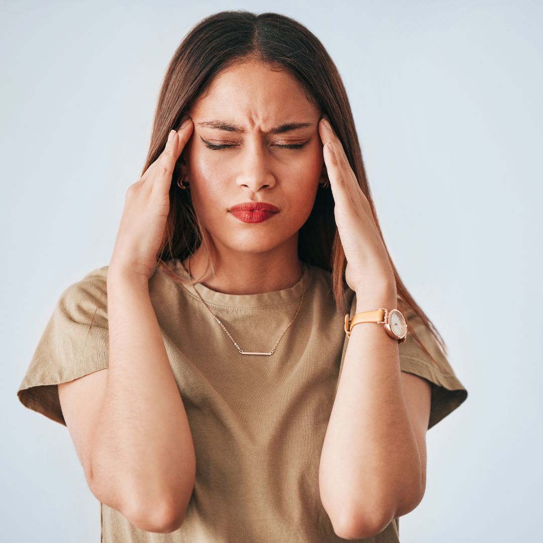 a woman holding her head in pain